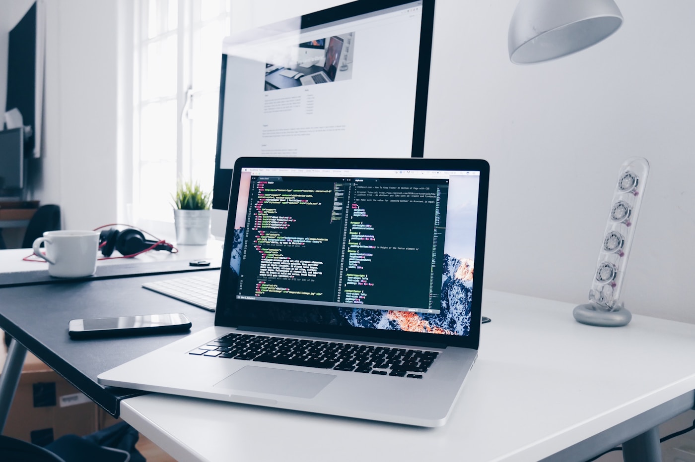 Laptop dengan kode website untuk layanan web hosting